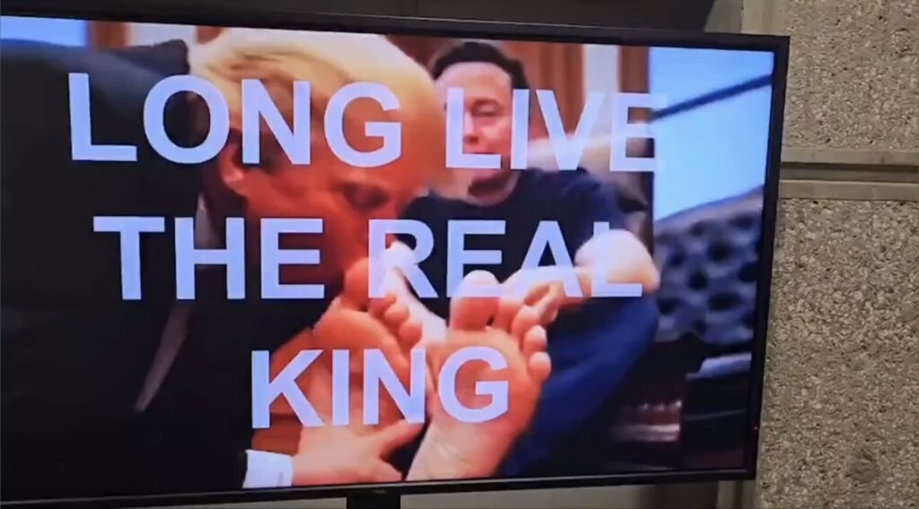 Image of AI-generated video depicting Donald Trump kissing the feet of Elon Musk with a text overlay that reads 'Long Live The Real King.'